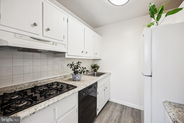 kitchen featuring tasteful backsplash, white cabinets, sink, and black appliances