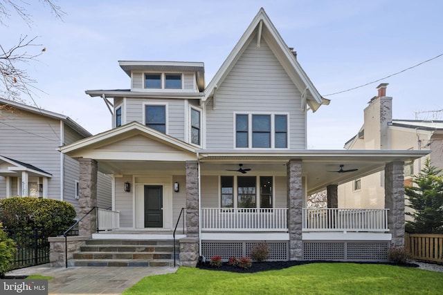 view of front of house with ceiling fan, a porch, and a front lawn