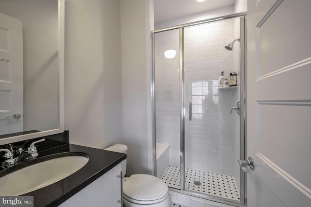 bathroom with an enclosed shower, vanity, and toilet