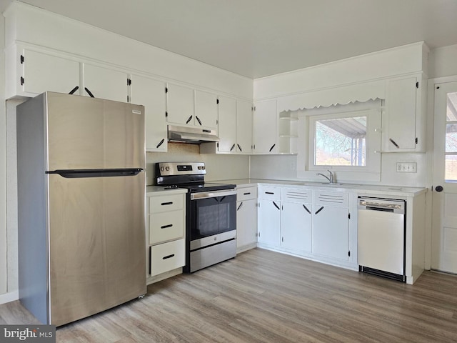 kitchen featuring sink, appliances with stainless steel finishes, tasteful backsplash, white cabinets, and light wood-type flooring