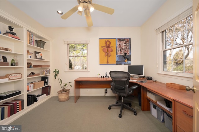 office area with carpet, baseboards, and a ceiling fan