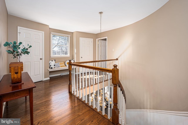 interior space with dark wood-style floors, visible vents, baseboards, and an upstairs landing