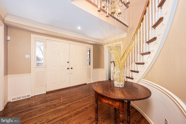 entryway with visible vents, a wainscoted wall, stairway, wood finished floors, and a notable chandelier