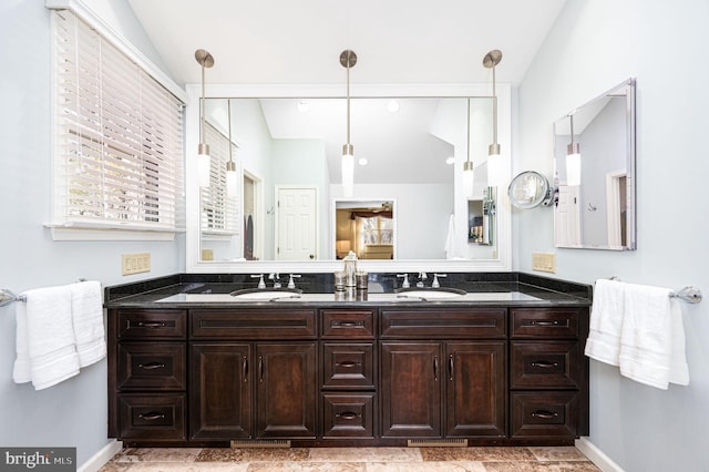 full bath with vaulted ceiling, a sink, and double vanity