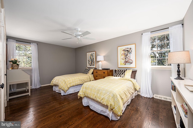 bedroom featuring ceiling fan, visible vents, baseboards, and wood finished floors