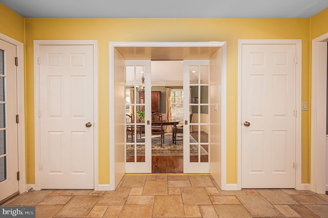 interior space featuring baseboards, french doors, and stone tile floors