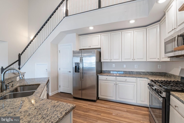 kitchen featuring white cabinets, stainless steel appliances, and sink