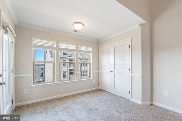 unfurnished bedroom with a closet, crown molding, and light colored carpet