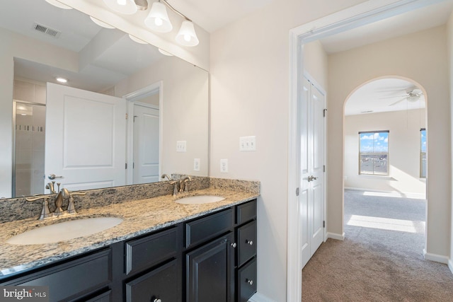 bathroom featuring vanity, walk in shower, and ceiling fan