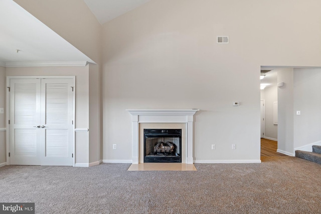 unfurnished living room featuring ornamental molding and light carpet