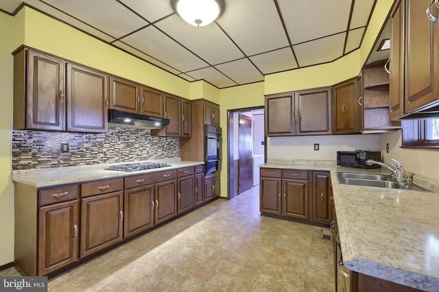 kitchen with sink, a paneled ceiling, dark brown cabinetry, tasteful backsplash, and black appliances