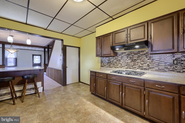 kitchen featuring dark brown cabinetry, stainless steel gas cooktop, a paneled ceiling, decorative light fixtures, and baseboard heating