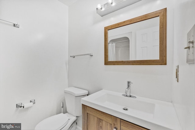 bathroom featuring vanity, toilet, and walk in shower