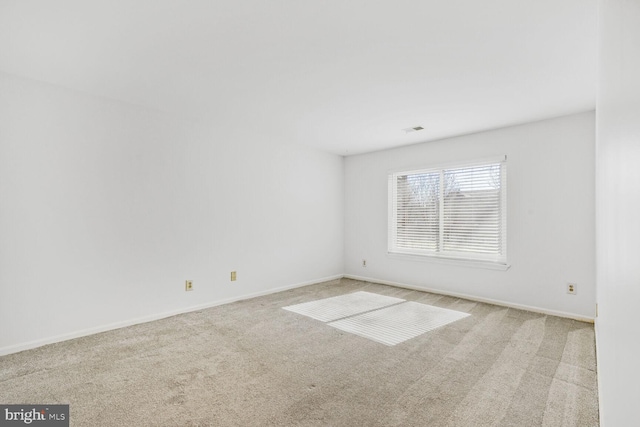 spare room featuring light colored carpet