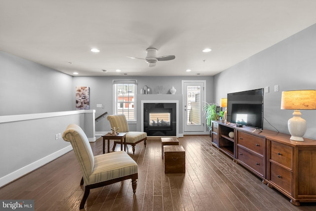 living area featuring recessed lighting, baseboards, a multi sided fireplace, and dark wood-style flooring