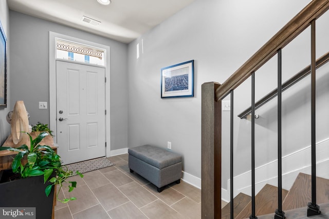 entryway featuring stairs, light tile patterned floors, baseboards, and visible vents