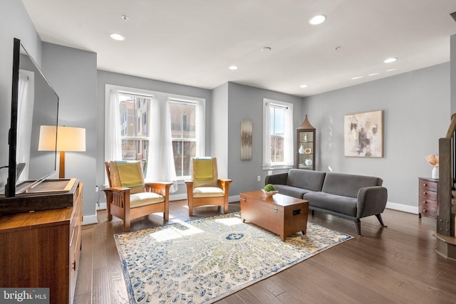 living area featuring recessed lighting, baseboards, and wood-type flooring