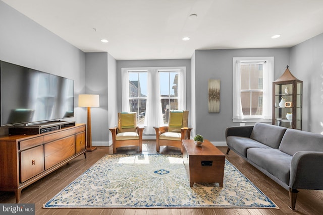 living area with recessed lighting, baseboards, and dark wood-type flooring