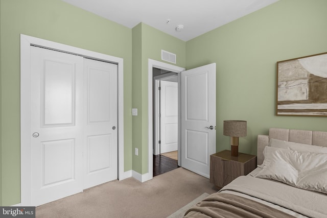 bedroom featuring a closet, visible vents, carpet flooring, and baseboards