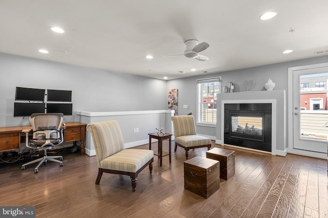 office with a wealth of natural light, a multi sided fireplace, and wood-type flooring