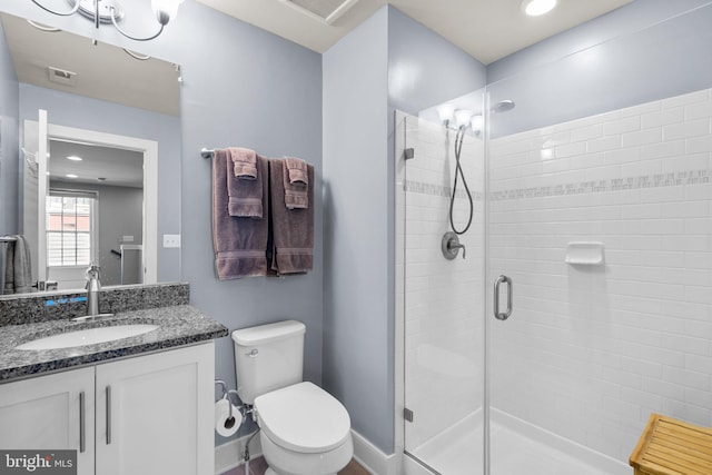 full bathroom with vanity, a shower stall, toilet, and baseboards