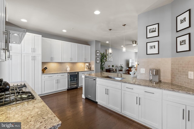 kitchen featuring beverage cooler, dark wood-style flooring, stainless steel appliances, a sink, and white cabinetry