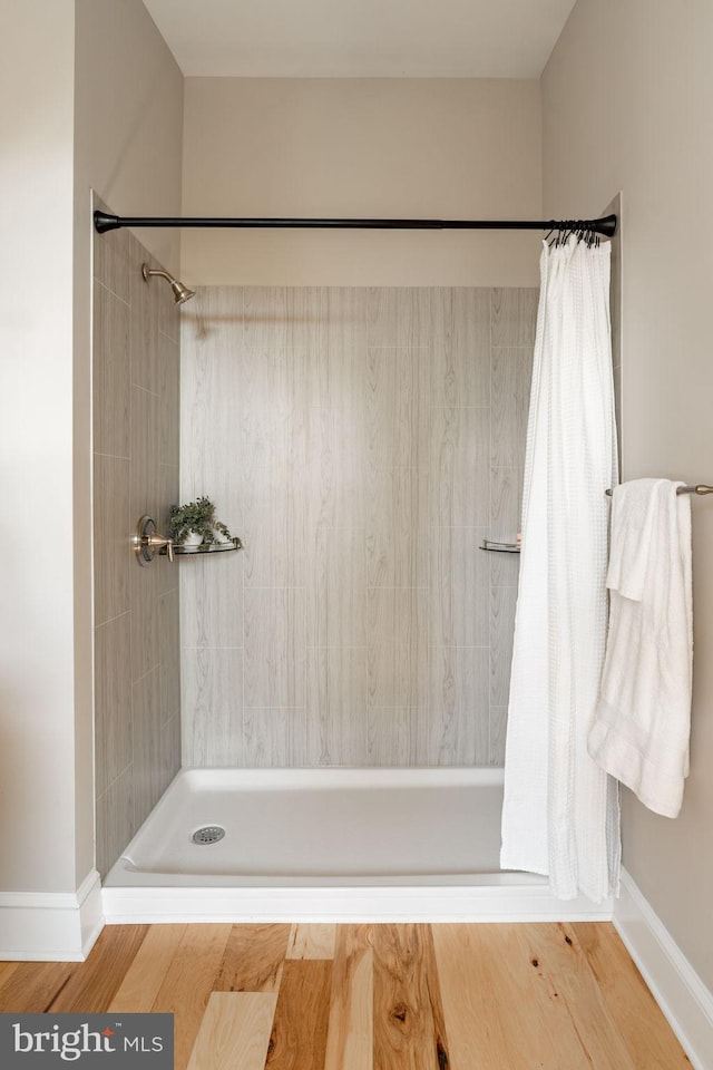 bathroom with wood-type flooring and walk in shower