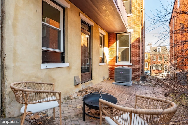 view of patio featuring cooling unit and a fire pit