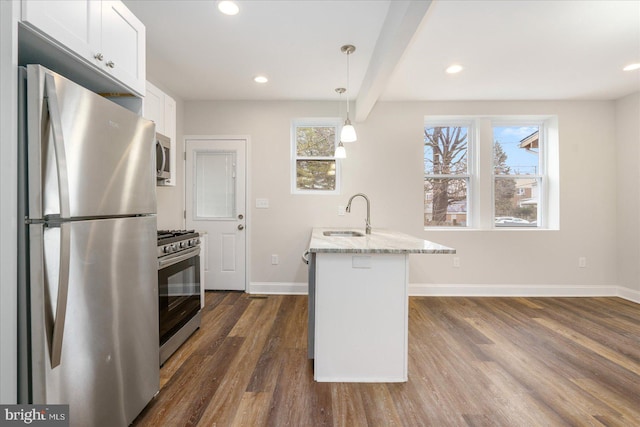 kitchen featuring hanging light fixtures, sink, light stone counters, appliances with stainless steel finishes, and white cabinets