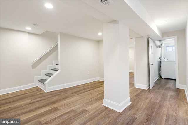 basement featuring hardwood / wood-style flooring and washer / dryer