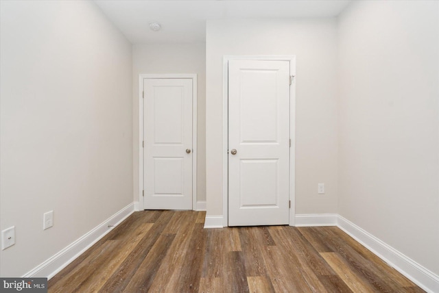 unfurnished bedroom with dark hardwood / wood-style flooring