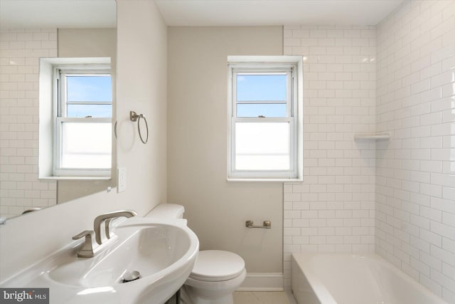 bathroom featuring plenty of natural light, sink, and toilet