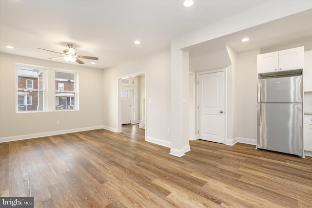 unfurnished living room featuring ceiling fan and light hardwood / wood-style flooring