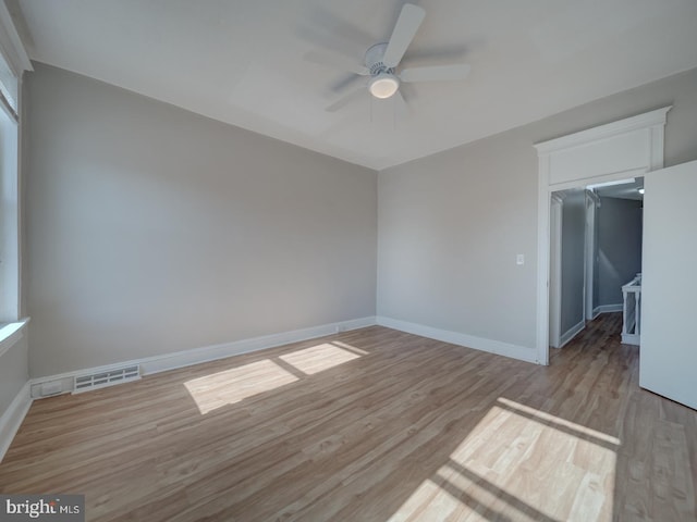 unfurnished bedroom featuring a walk in closet, a closet, visible vents, light wood-type flooring, and baseboards