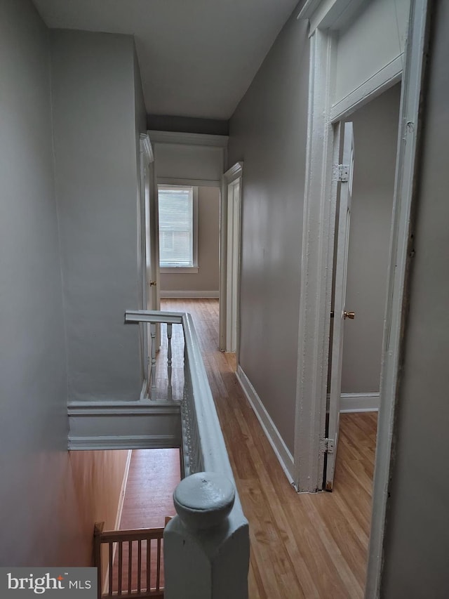 hall featuring light wood-style floors and baseboards