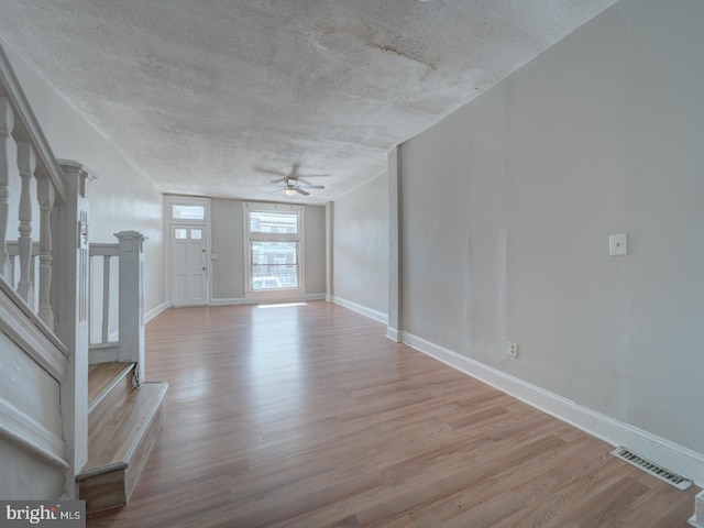 entrance foyer with stairs, wood finished floors, visible vents, and baseboards