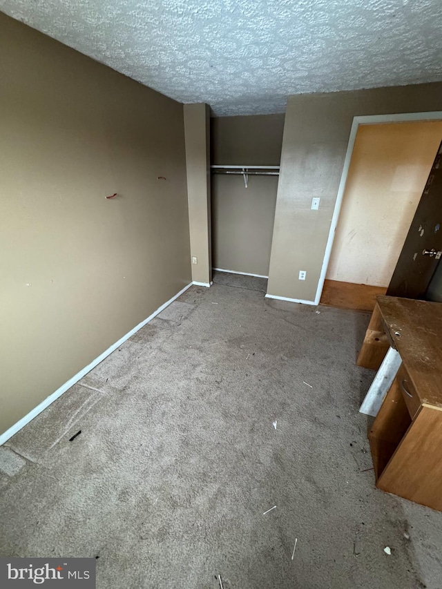 unfurnished bedroom with a closet, carpet floors, and a textured ceiling