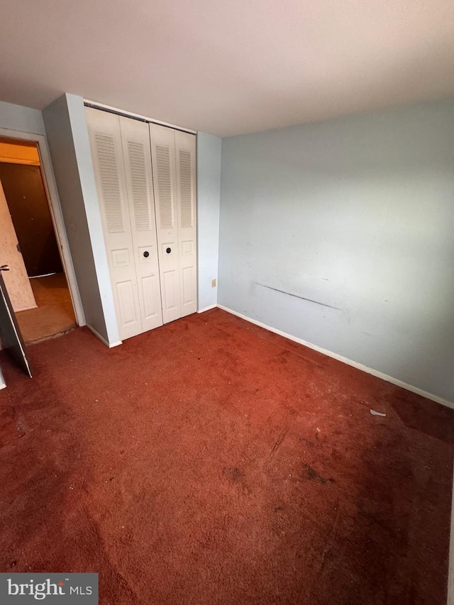 unfurnished bedroom featuring carpet floors and a closet