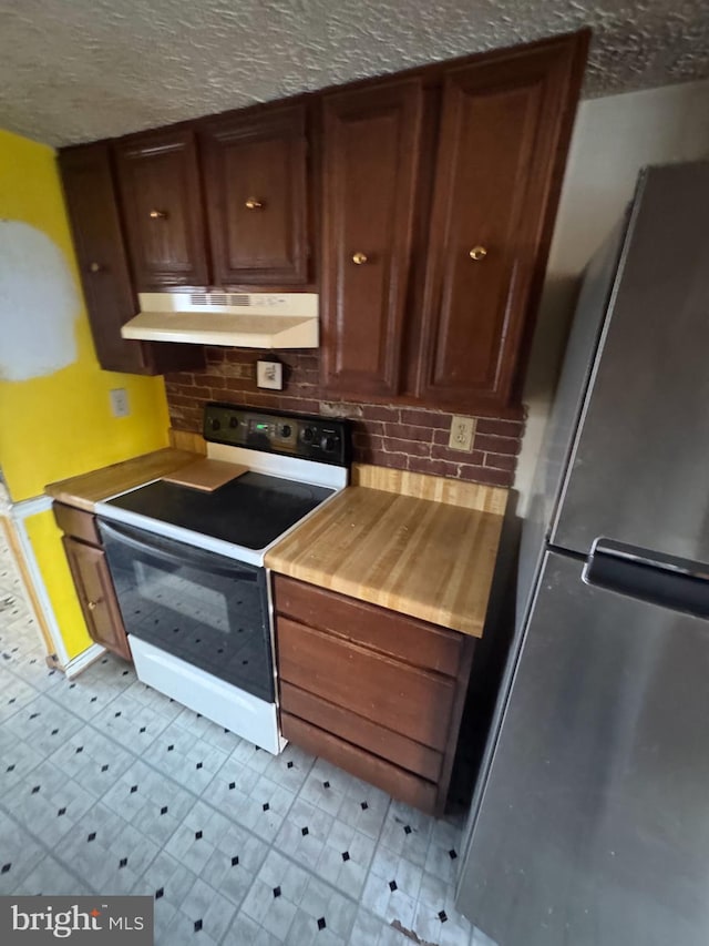 kitchen with range with electric stovetop, a textured ceiling, stainless steel refrigerator, and decorative backsplash