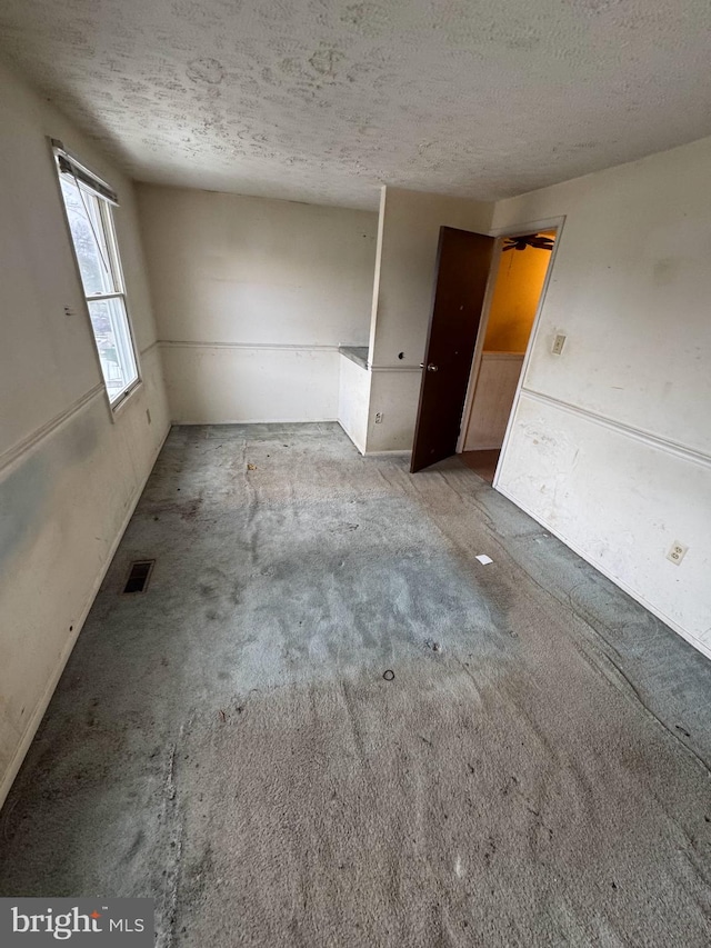 empty room featuring carpet floors and a textured ceiling