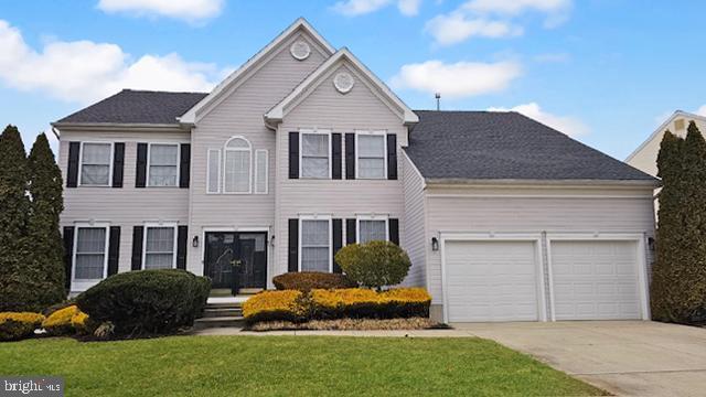 view of front of property featuring a garage and a front lawn