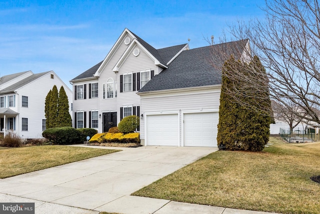 view of front facade featuring driveway, a front lawn, roof with shingles, and an attached garage