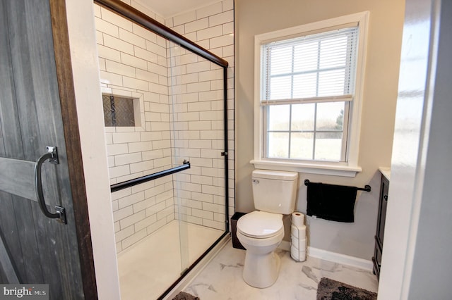 bathroom with toilet, vanity, and a shower with shower door