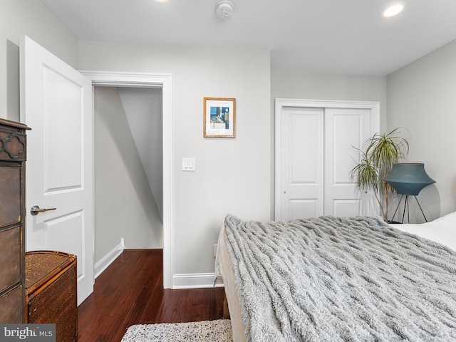 bedroom with dark wood-type flooring and a closet