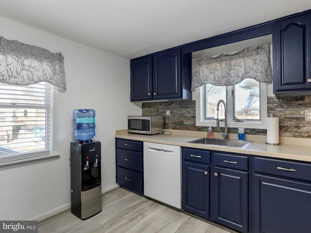 kitchen featuring light countertops, dishwasher, a sink, and stainless steel microwave