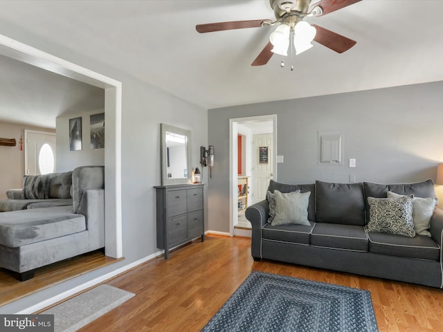 living area with ceiling fan, wood finished floors, and baseboards