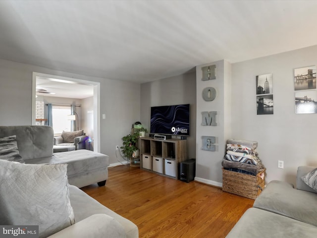 living area with baseboards and wood finished floors