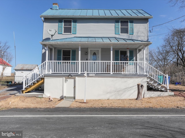 view of front of home featuring metal roof, a standing seam roof, stairs, and a porch