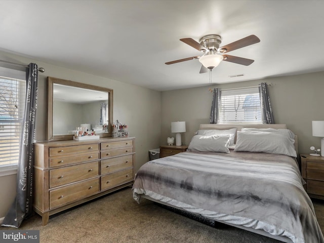 bedroom featuring a ceiling fan, visible vents, and carpet flooring