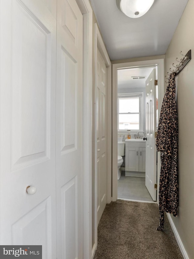 hallway featuring carpet and visible vents